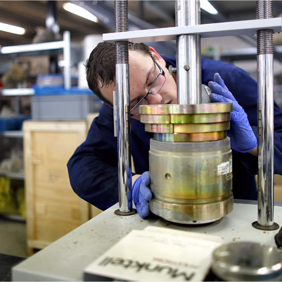 A material sample is tested using a laboratory press to assess its quality and strength.