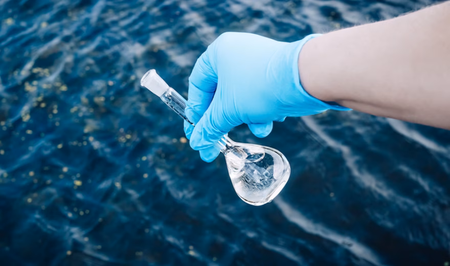 Een watermonster wordt genomen uit oppervlaktewater voor onderzoek naar waterkwaliteit en milieuparameters.