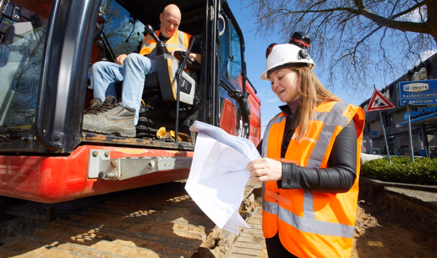 Medewerkers controleren plannen en werkzaamheden tijdens een bouwproject.