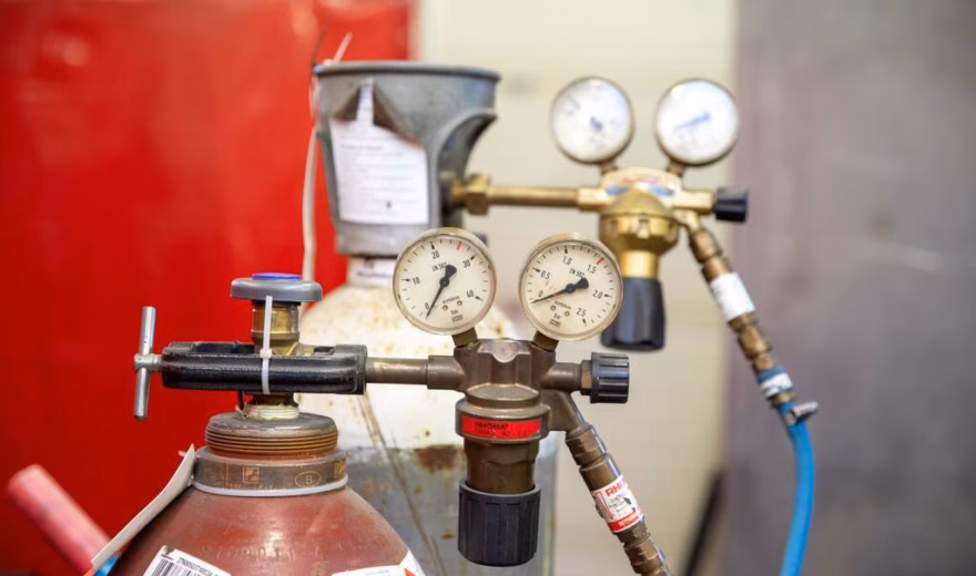 Gascilinders met aangesloten drukmeters en regelapparatuur voor gecontroleerde gasvoorziening.
