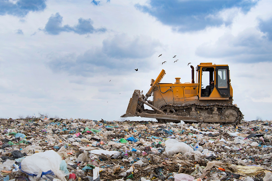 A bulldozer moves waste at a landfill during waste disposal operations.
