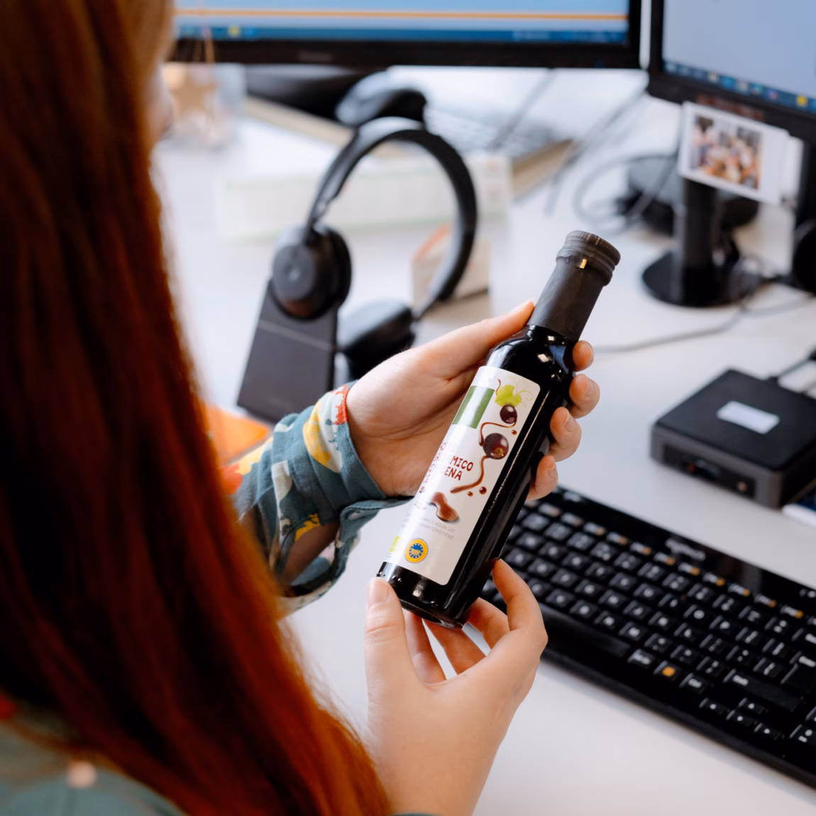 Medewerker beoordeelt een voedingsproduct aan de hand van productinformatie op een computerscherm.