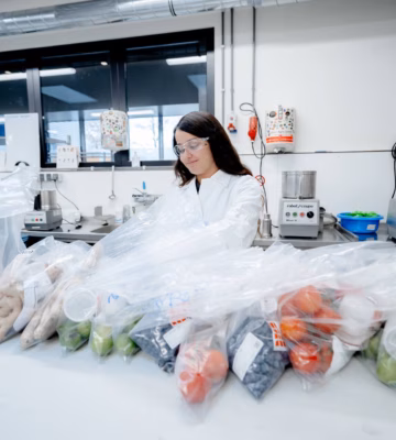 Laboratorium voor voedselveiligheid met verpakte groenten en fruit op een werktafel.