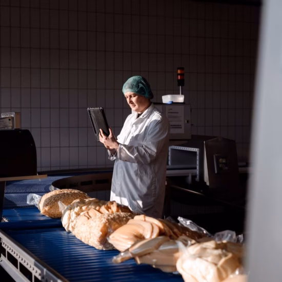 Medewerker voert digitale kwaliteitscontrole uit met tablet in productieomgeving.