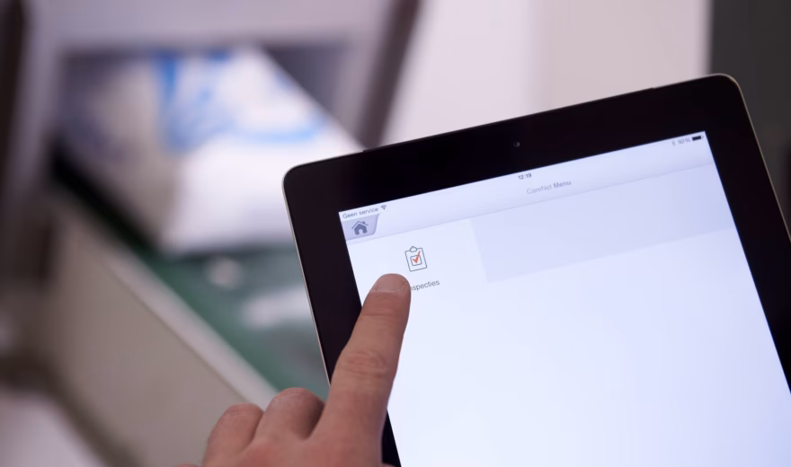 Aanraakscherm voor digitale registratie of toegangscontrole met vinger die een optie selecteert.