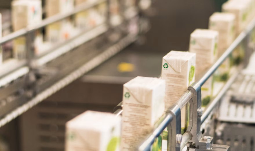 Verpakte producten worden geautomatiseerd verwerkt op een productielijn.
