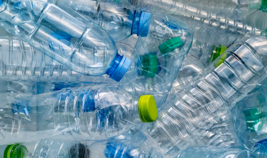 Samengeperste kunststof flessen tonen een stroom van recyclebaar verpakkingsmateriaal.