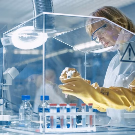 Een laboratoriummedewerker onderzoekt een monster in een gecontroleerde laboratoriumomgeving.