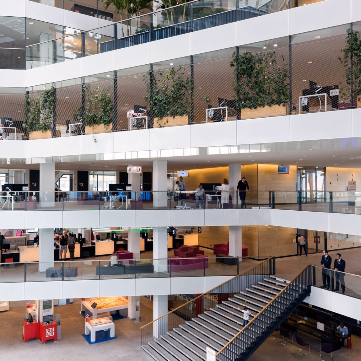 Modern kantoorgebouw met open atrium, meerdere verdiepingen en flexibele werkplekken.