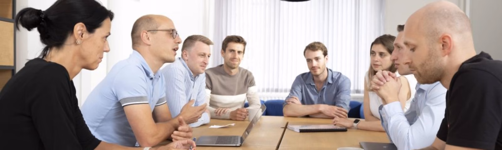Een groep professionals bespreekt gezamenlijk projecten en samenwerking tijdens een vergadering.