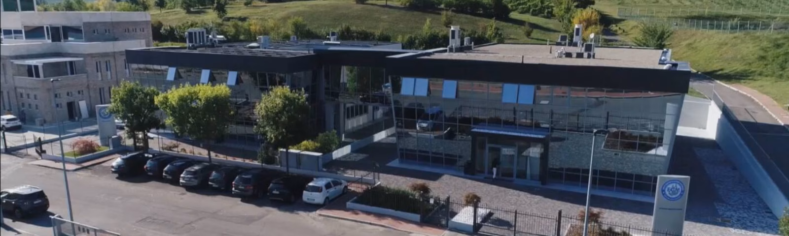 Modern bedrijfsgebouw met onderzoeks- of productiefaciliteiten in een groene omgeving.