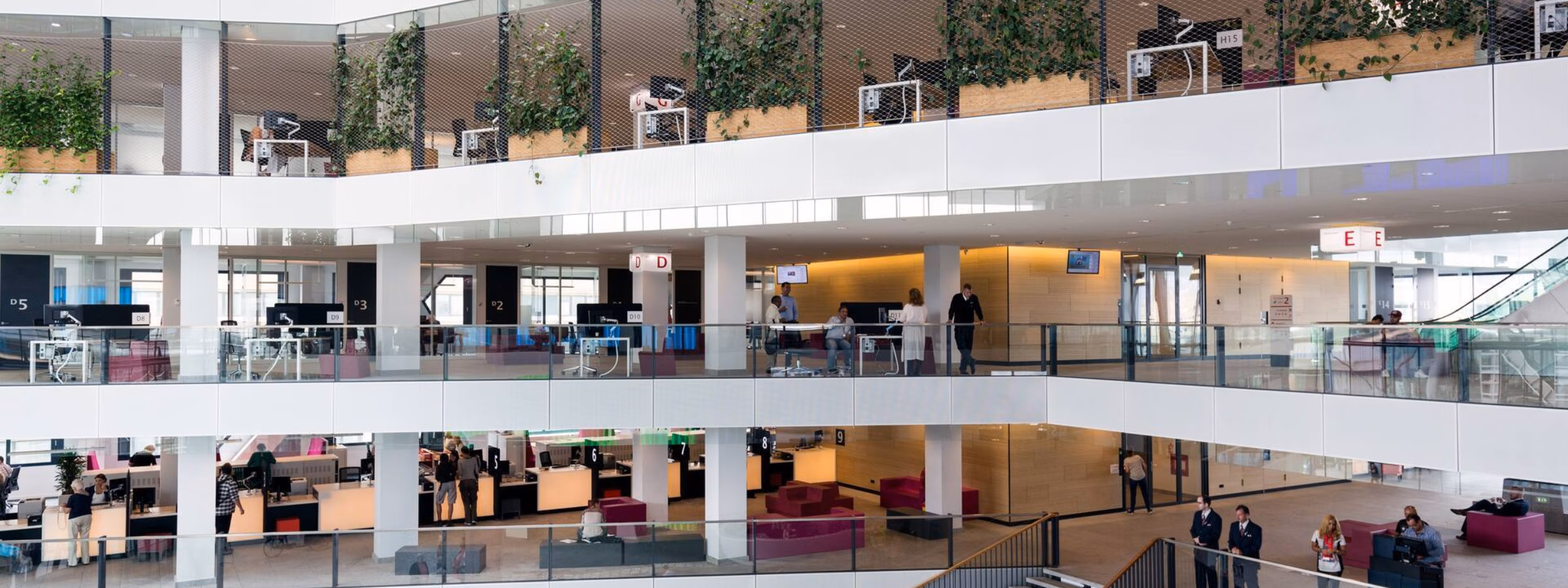 Modern kantoorgebouw met open atrium, meerdere verdiepingen en flexibele werkplekken.