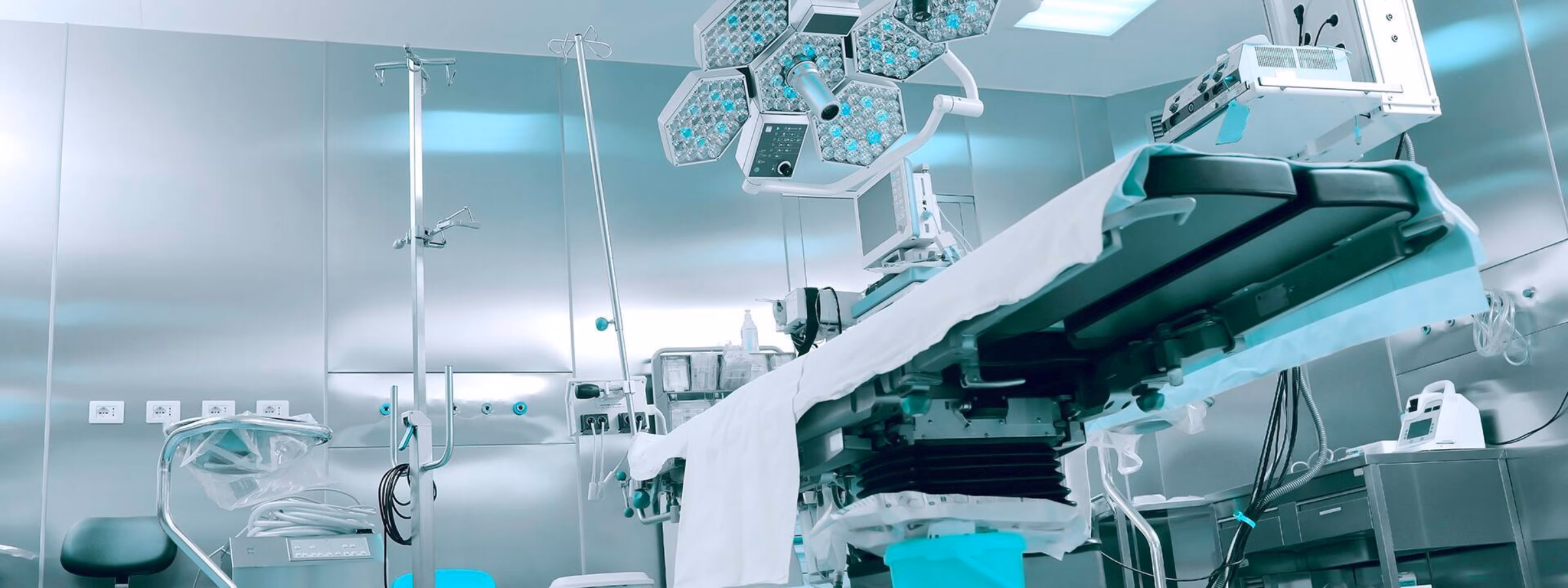 Modern operating room with an operating table, surgical lights, and medical equipment for surgical procedures.