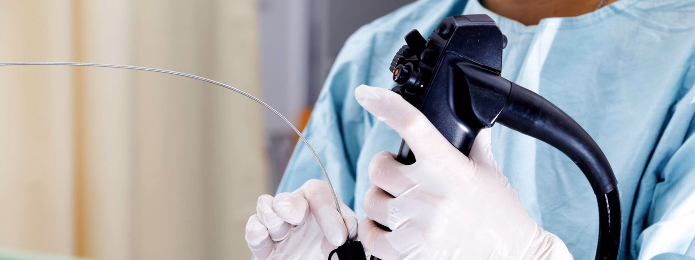 A medical specialist prepares an endoscope for examination or treatment in a clinical setting.