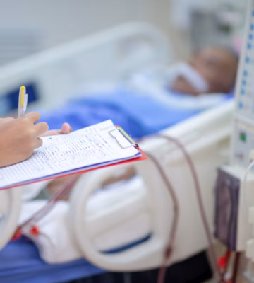 Ziekenhuisomgeving met medisch apparaat naast een patiëntbed en een zorgmedewerker die gegevens noteert op een formulier.