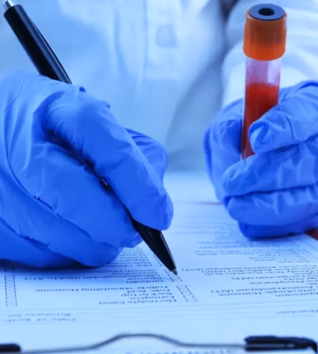 Een laboratoriummedewerker registreert gegevens van een bloedmonster voor analyse en kwaliteitscontrole.