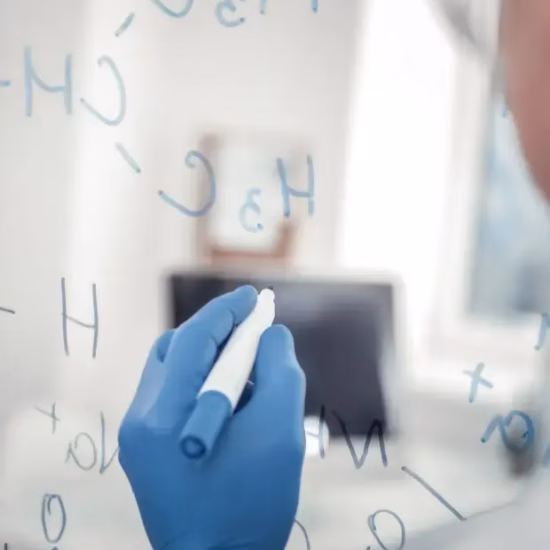 Een laboratoriummedewerker noteert chemische structuren voor onderzoek en analyse.