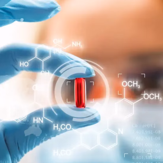 A red capsule is held between laboratory gloves, with visual references to pharmaceutical research.