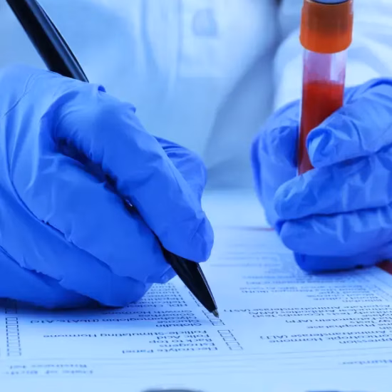 Een laboratoriummedewerker registreert gegevens van een bloedmonster voor analyse en kwaliteitscontrole.