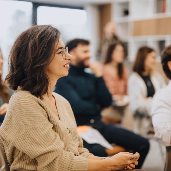 Deelnemers luisteren naar een presentatie tijdens een training, workshop of kennisbijeenkomst.