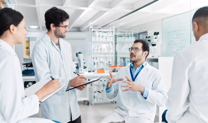 Onderzoeksteam bespreekt laboratoriumresultaten in een moderne onderzoeksruimte.