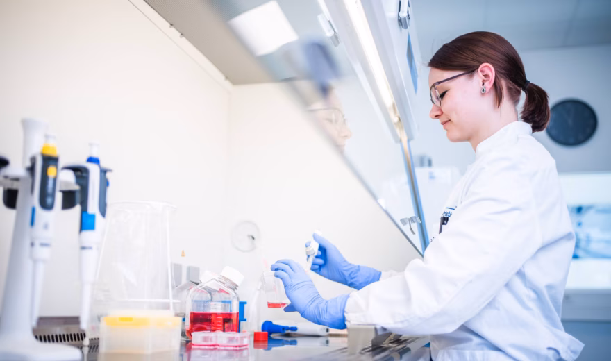 Laboratoriummedewerker voert een analyse uit met laboratoriummateriaal aan een werkbank