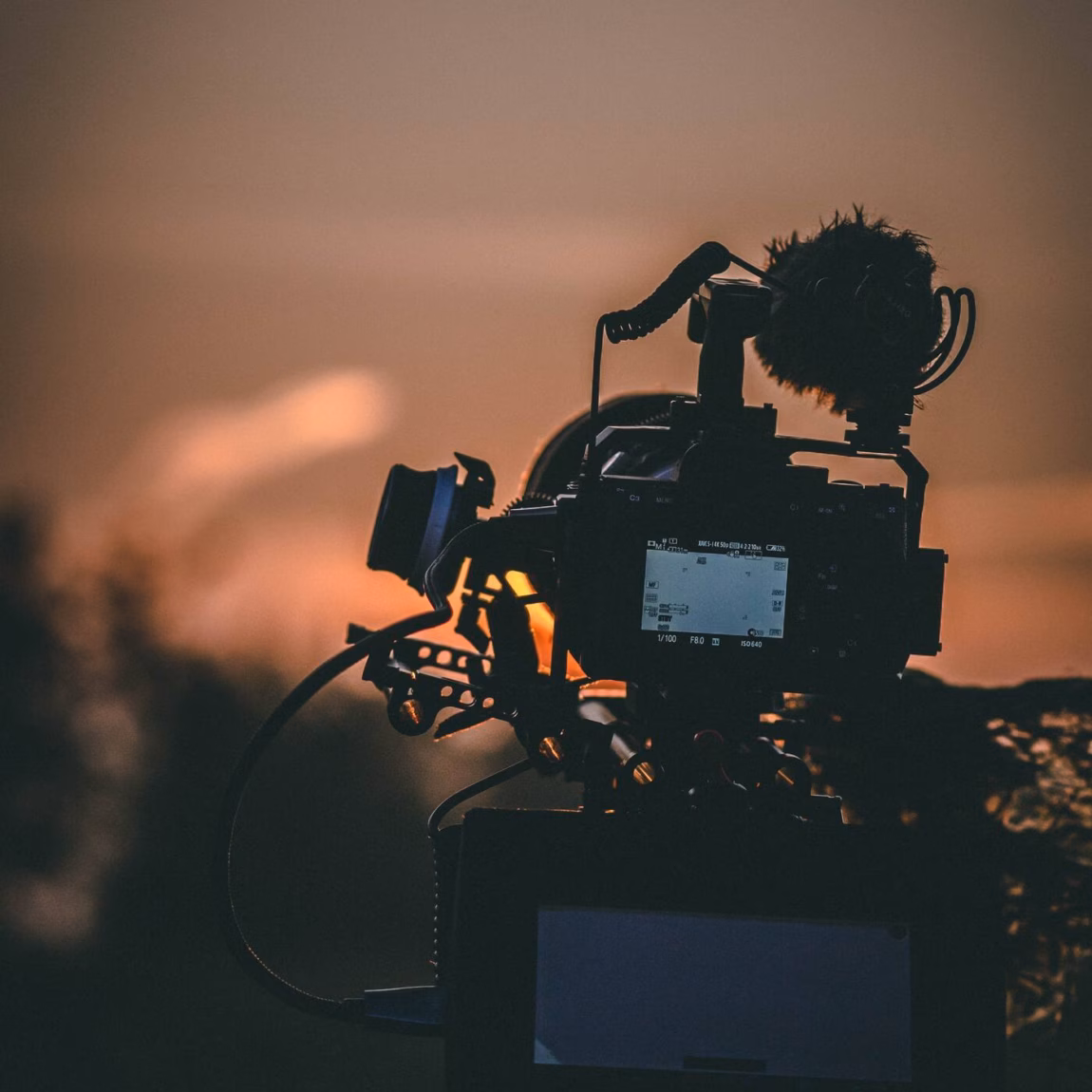 Professionele videocamera filmt een scène tijdens een opname bij weinig licht.