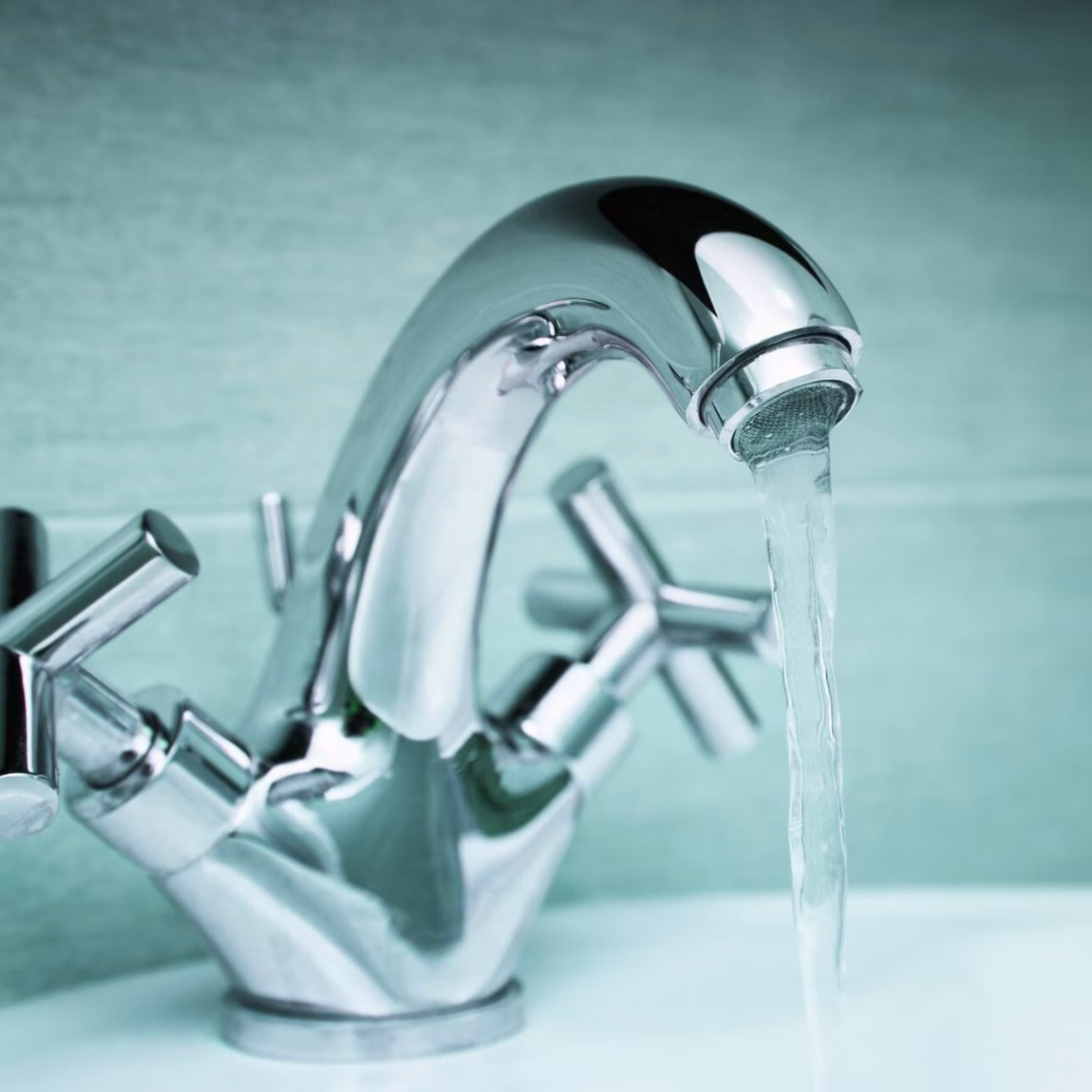 Robinet d'eau courante au-dessus d'un lavabo dans une salle de bains.