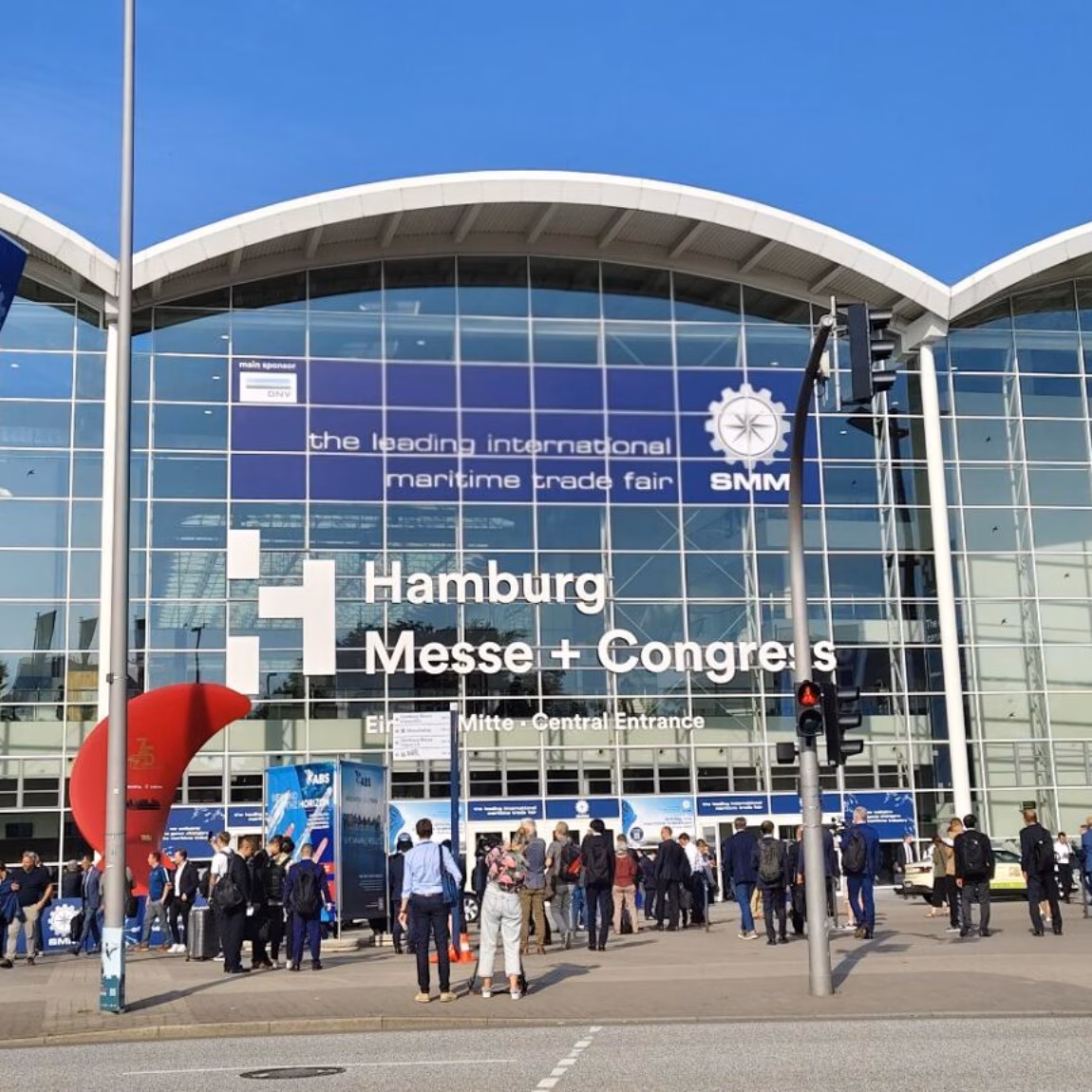 Bezoekers staan voor de ingang van het Hamburg Messe und Congress beurscomplex.
