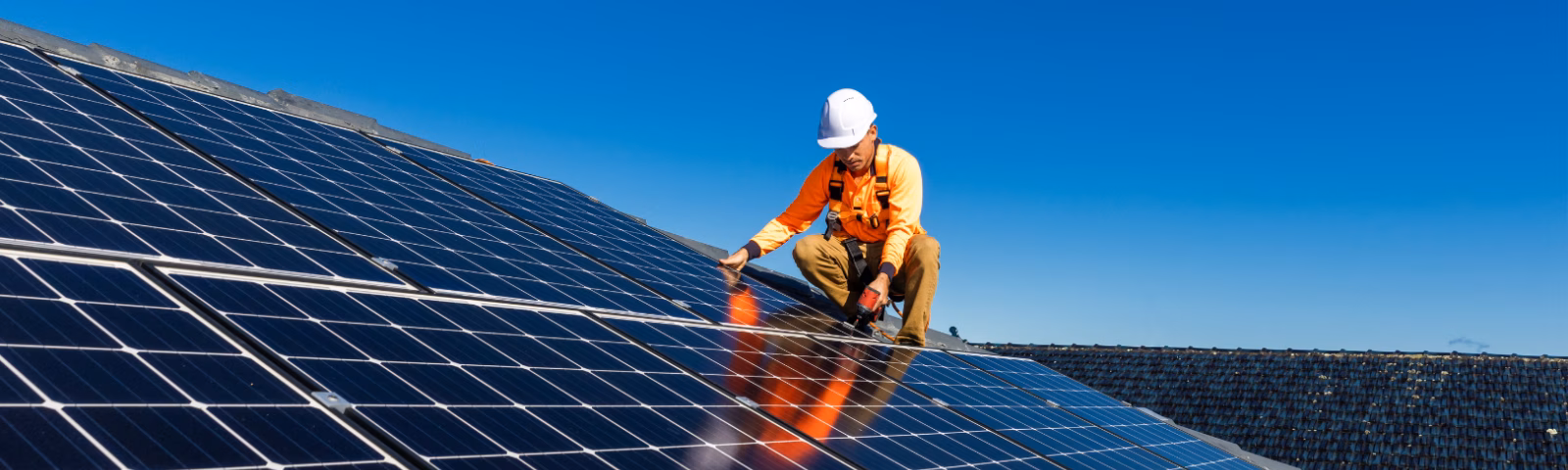 Technicus inspecteert zonnepanelen op een zonnepark tijdens onderhouds- of controlewerkzaamheden.