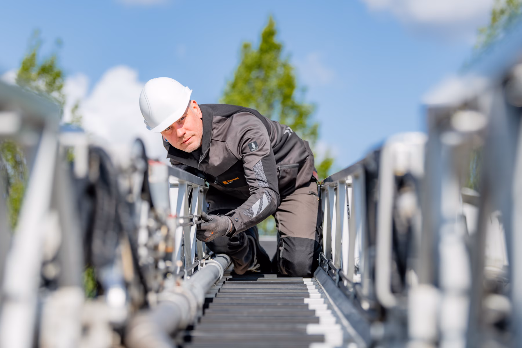 Technisch medewerker voert inspectie- of onderhoudswerkzaamheden uit aan een industriële installatie op hoogte.