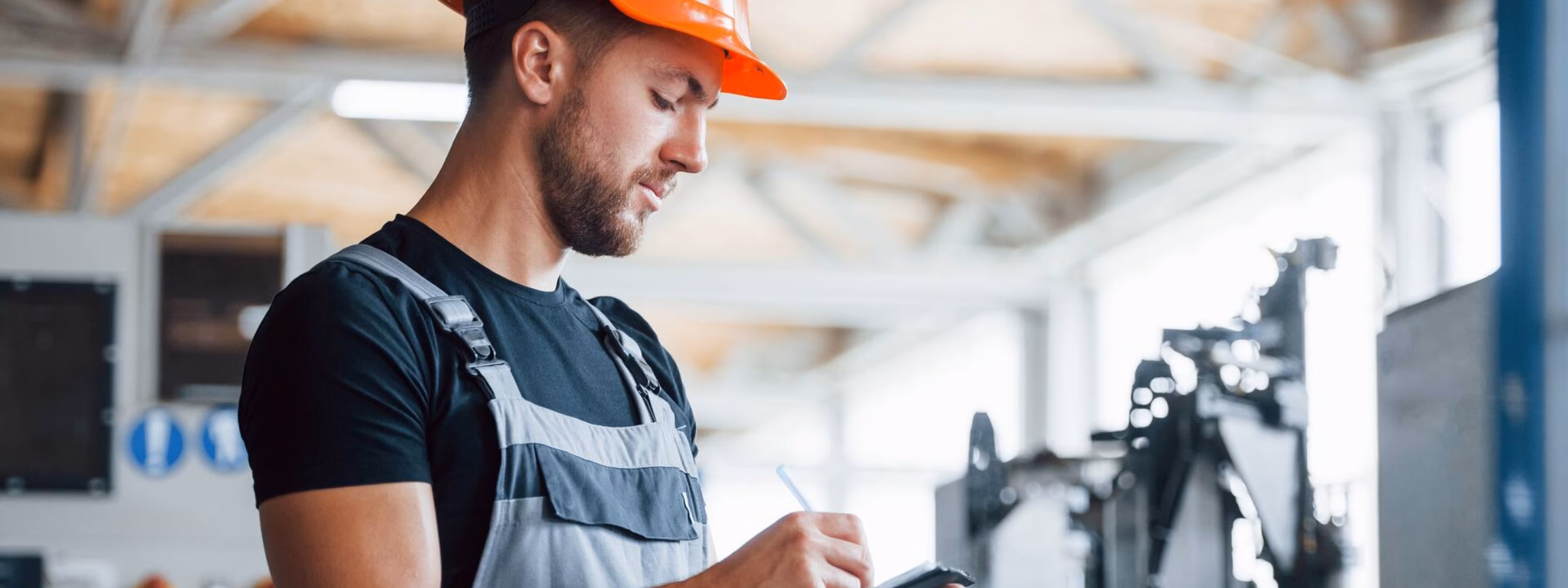 Technisch medewerker voert een inspectie uit op een tablet in een industriële productieomgeving.