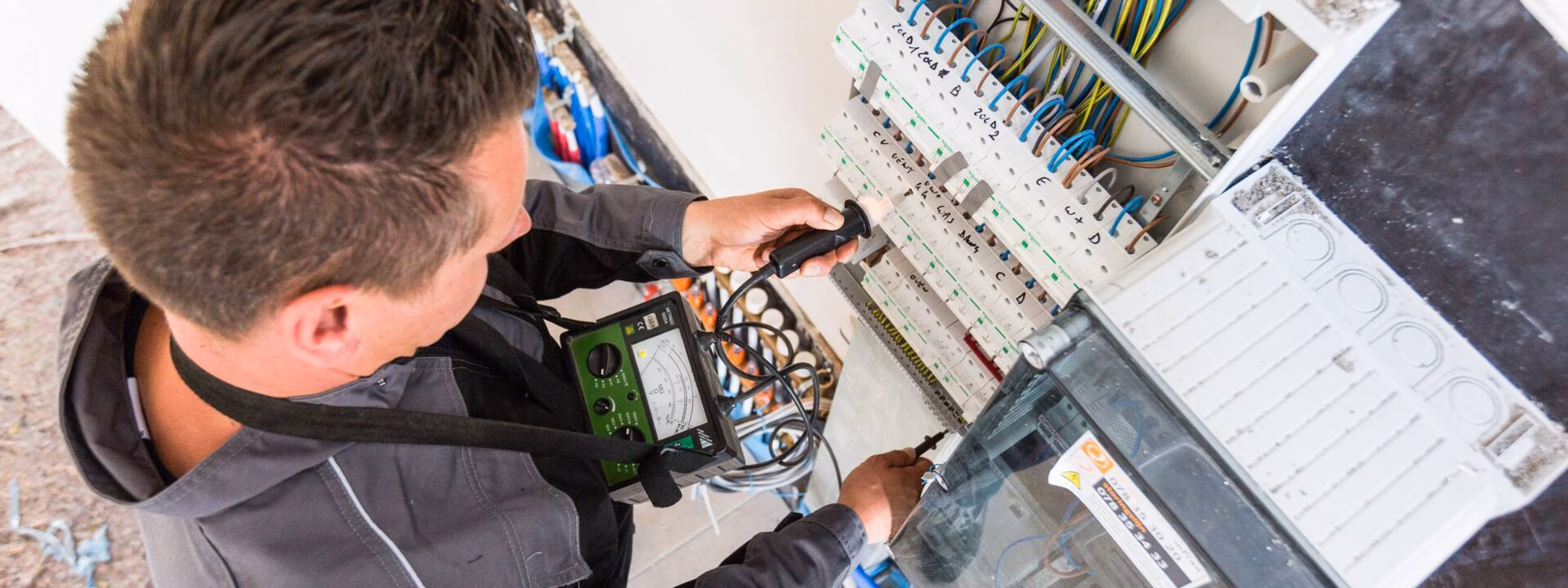 Un technicien vérifie une installation électrique et le câblage dans une armoire électrique lors d'une inspection de sécurité.