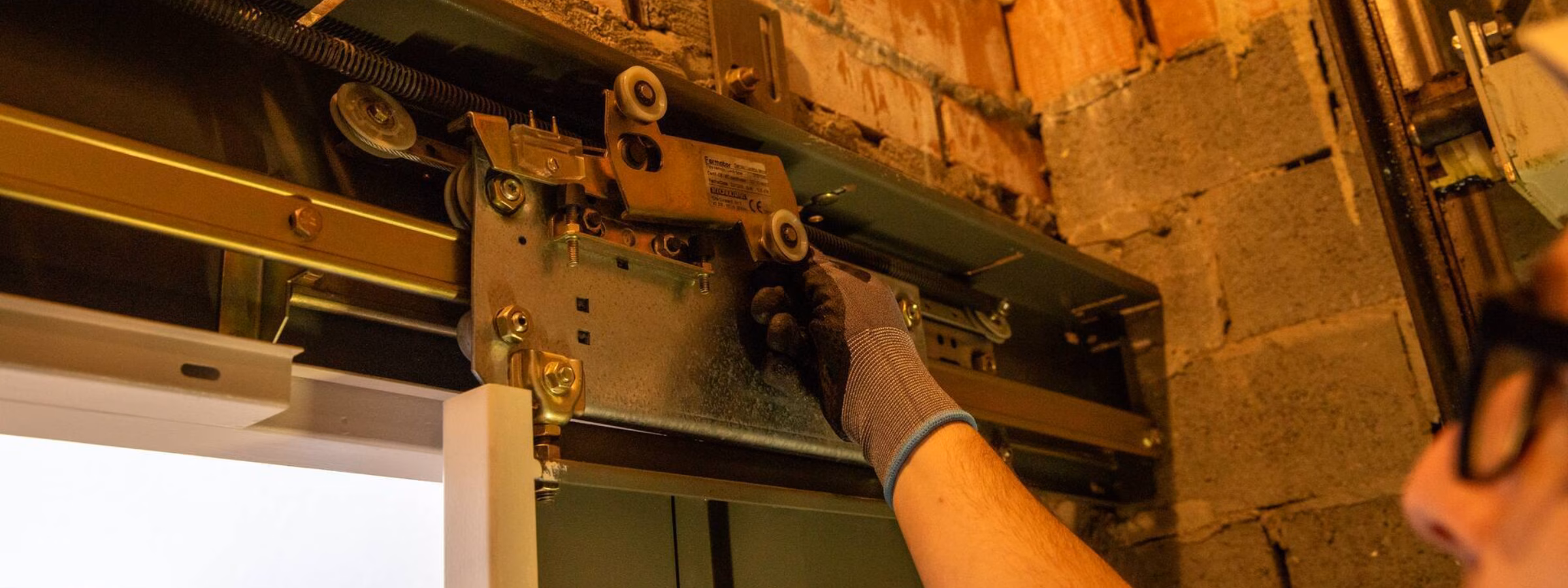 Ein Techniker führt eine Inspektion oder Einstellung eines Türmechanismus in einer bestehenden gemauerten Konstruktion durch.