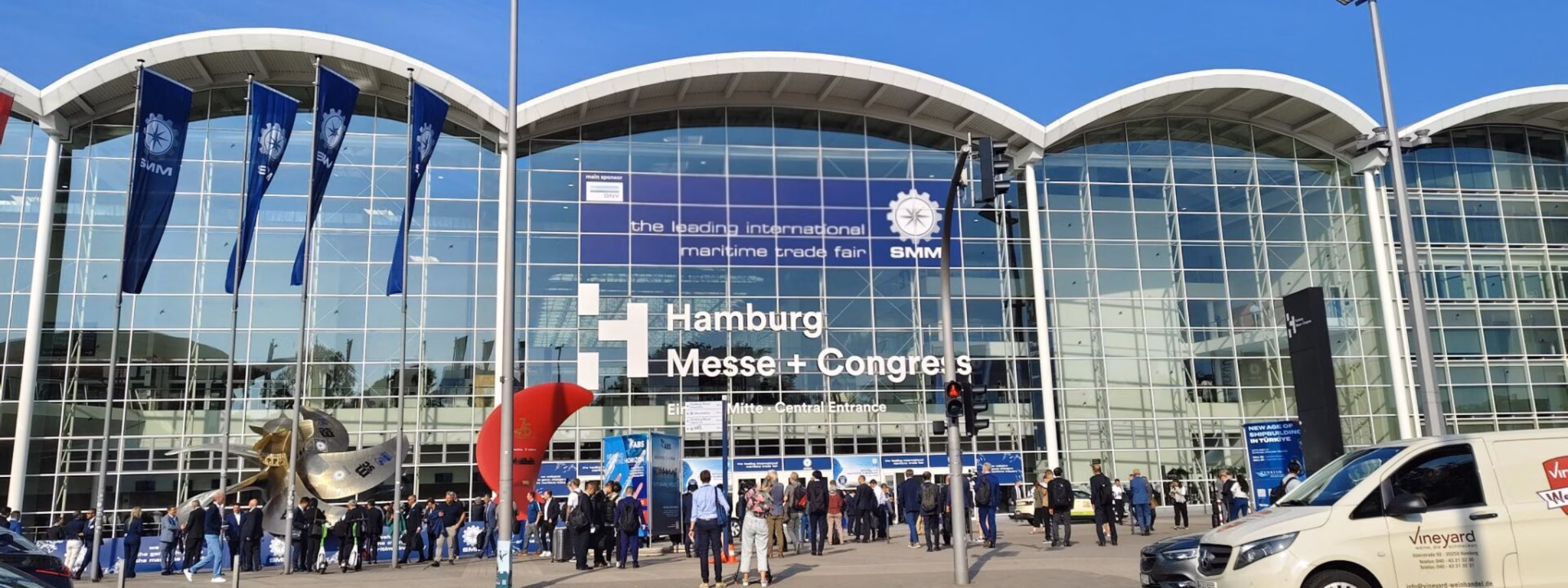 Bezoekers staan voor de ingang van het Hamburg Messe und Congress beurscomplex.