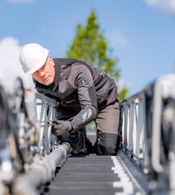 Technisch medewerker voert inspectie- of onderhoudswerkzaamheden uit aan een industriële installatie op hoogte.