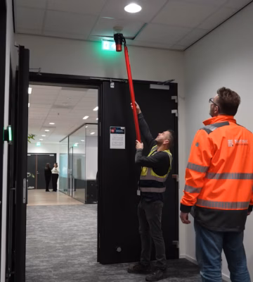 Twee experts die de brandveiligheid van een gebouw controleren en inspecteren om de veiligheid en naleving van brandveiligheidsvoorschriften te waarborgen.