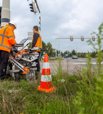 Les collaborateurs effectuent des mesures de circulation à un carrefour à l'aide d'appareils de mesure et de systèmes d'enregistrement du trafic.