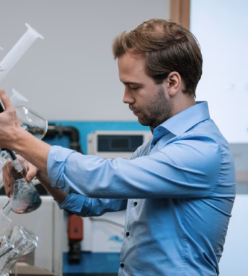 Un technicien de laboratoire effectue une analyse de l'eau à l'aide de verrerie et d'appareils de mesure destinés à l'étude de la qualité et de la sécurité de l'eau.