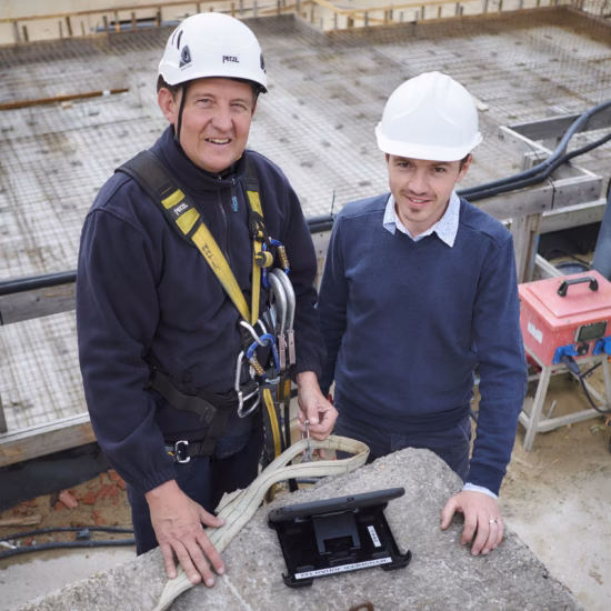 Deux employés inspectent une installation sur un chantier en cours de construction.