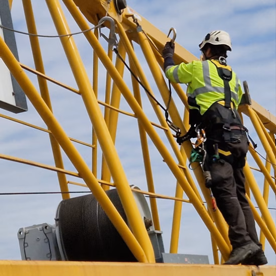 Een inspecteur controleert een stalen constructie op hoogte om de technische staat en veiligheid te beoordelen.