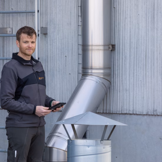 Un technicien contrôle un système de ventilation dans un environnement industriel.