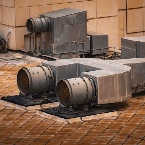 Ventilatie- en afzuiginstallaties geplaatst op een dak van een industrieel gebouw.