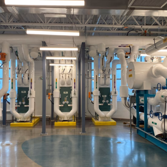 Koeltechnische installatie met geïsoleerde leidingen, afsluiters en drukmeters voor systeembewaking.