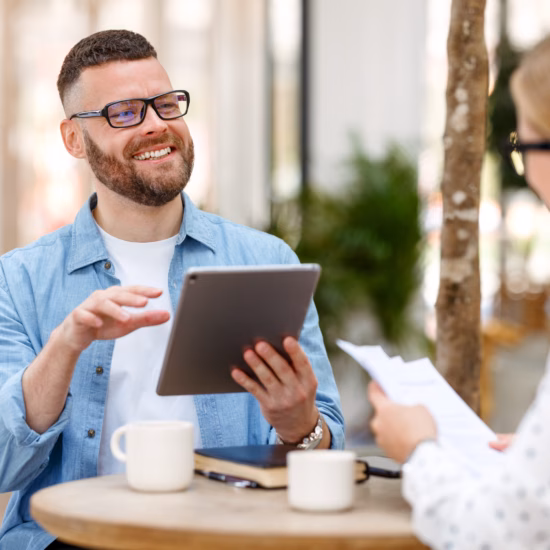 Twee personen bespreken informatie en documenten tijdens een zakelijk overleg.