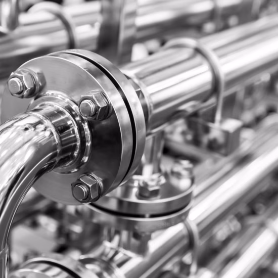 Rvs-leidingen en koppelingen maken deel uit van een industriële installatie voor vloeistofverwerking.