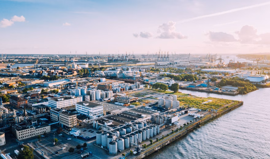 Luchtfoto van een industriële waterzuiveringsinstallatie aan het water.