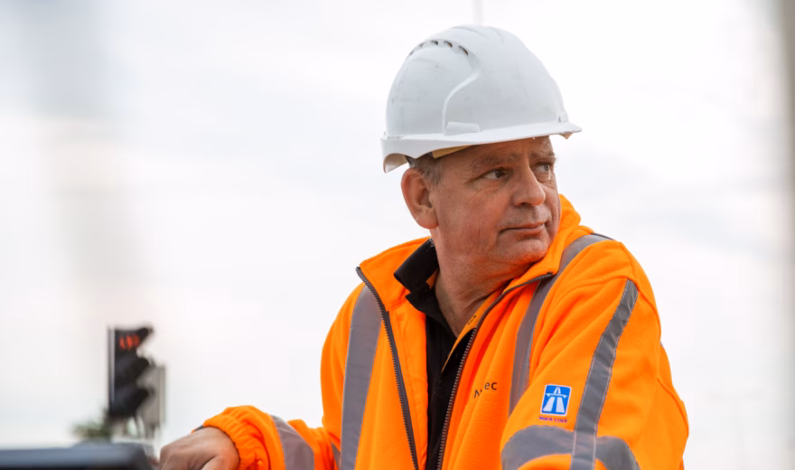 Un employé en tenue de sécurité effectue une inspection sur un site industriel.
