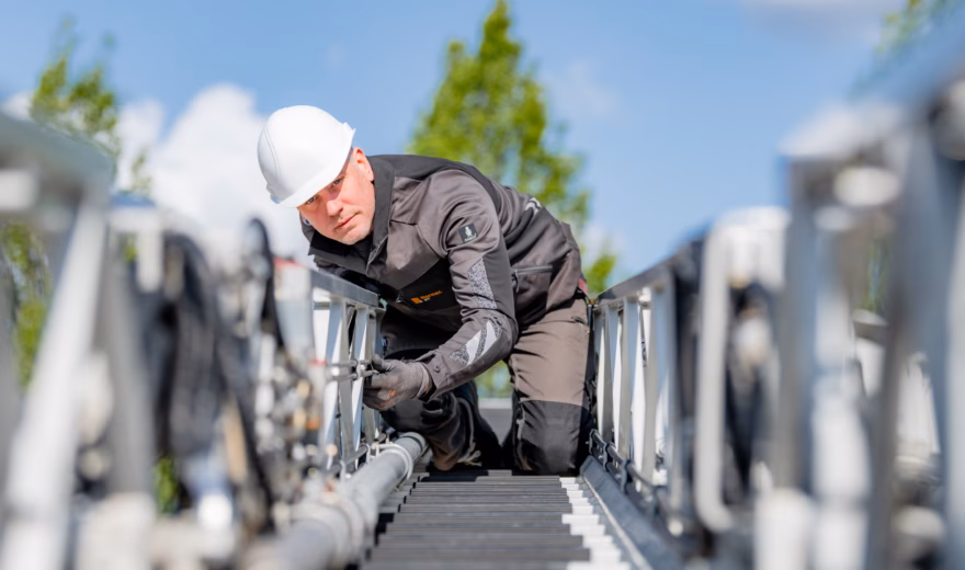 Technisch medewerker voert inspectie- of onderhoudswerkzaamheden uit aan een industriële installatie op hoogte.