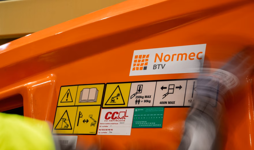 Photo détaillée des autocollants de sécurité et du marquage Normec BTV sur une nacelle élévatrice.